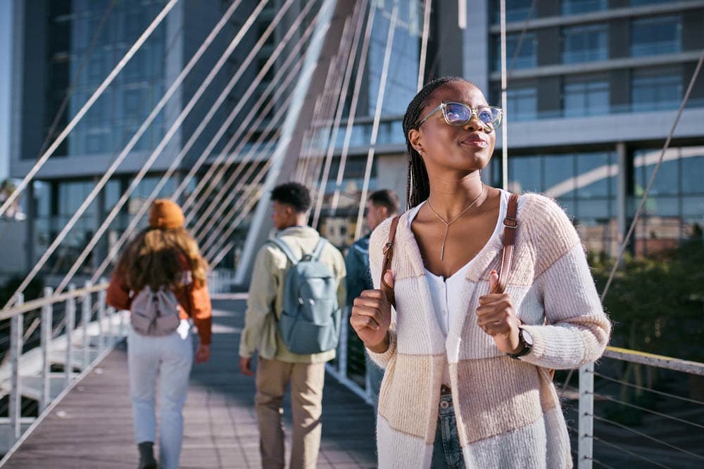 A teenager walking confidently across a bridge with friends in the background, symbolizing resilience, self-esteem growth, and coping with rejection sensitivity in ADHD.