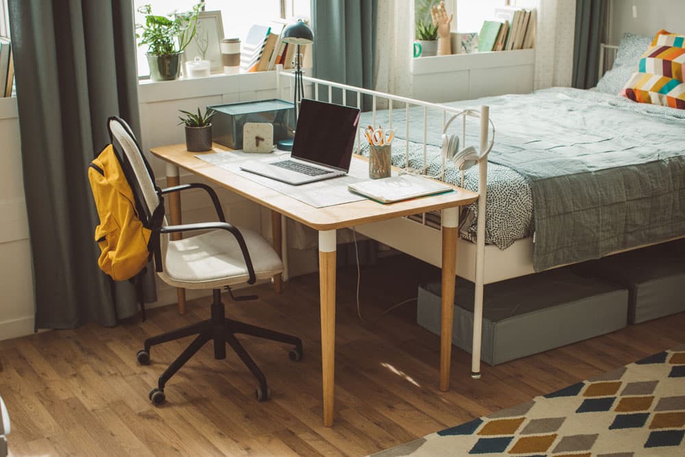 A neatly organized dorm room with a desk, laptop, and study materials, representing how routines and structured environments support students with ADHD in dorm life.