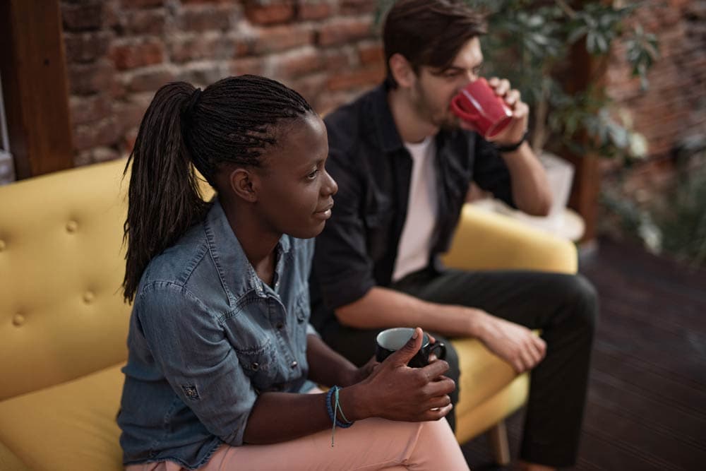 A woman and man sitting together with coffee, representing the gender differences in emotional and behavioural ADHD symptoms.