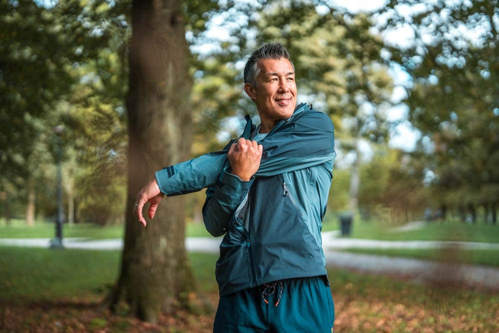 A man stretching outdoors before exercising, representing how regular physical activity supports executive function, focus, and emotional regulation in individuals with ADHD.