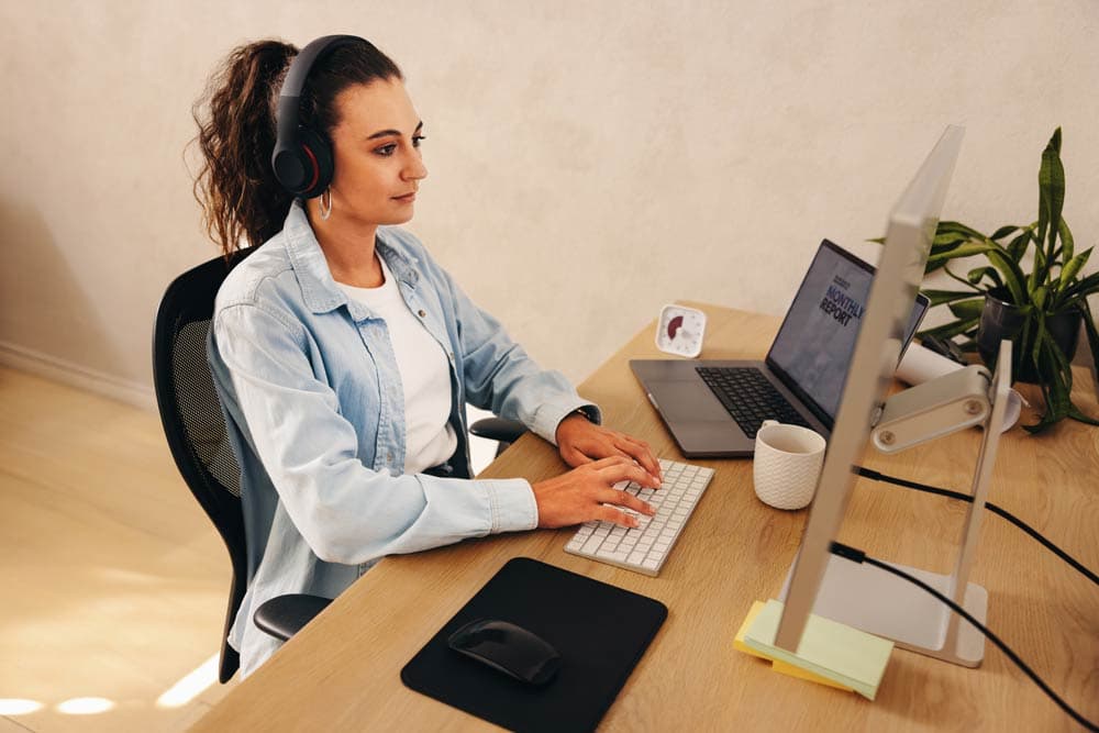 A student wearing headphones working at a computer, representing strategies for breaking large tasks into smaller, manageable steps for ADHD focus and productivity.