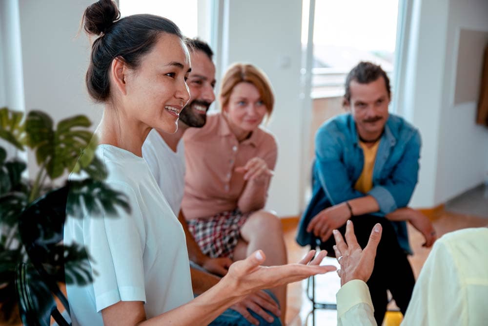 Adults sitting together in a supportive group discussion about overcoming ADHD stigma.