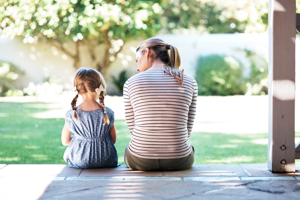 Mother and daughter sitting together outdoors, representing conversations about ADHD prevalence and diagnosis across childhood and adulthood in Canada.