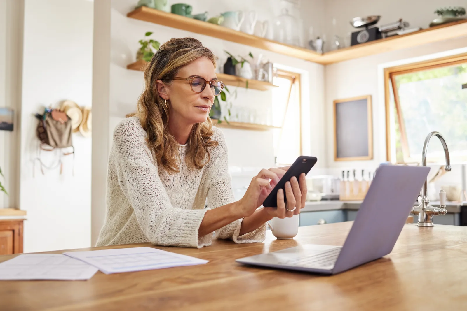 Person reviewing the cost of an online ADHD assessment on a phone while sitting at a kitchen table