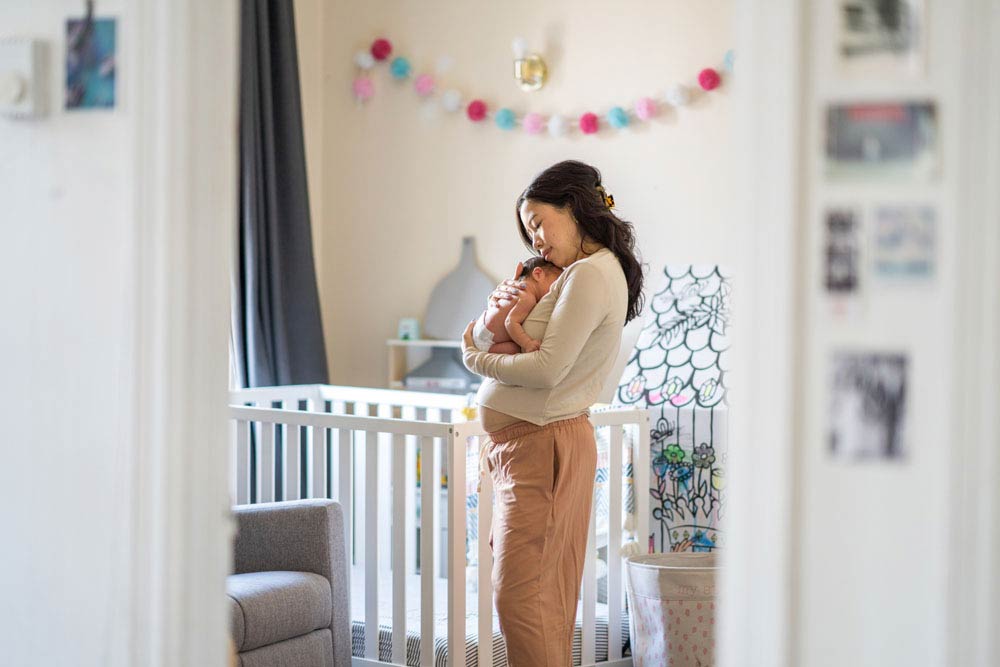 Mother holding newborn baby in nursery, symbolizing the challenges and strategies of managing ADHD during pregnancy and postpartum.