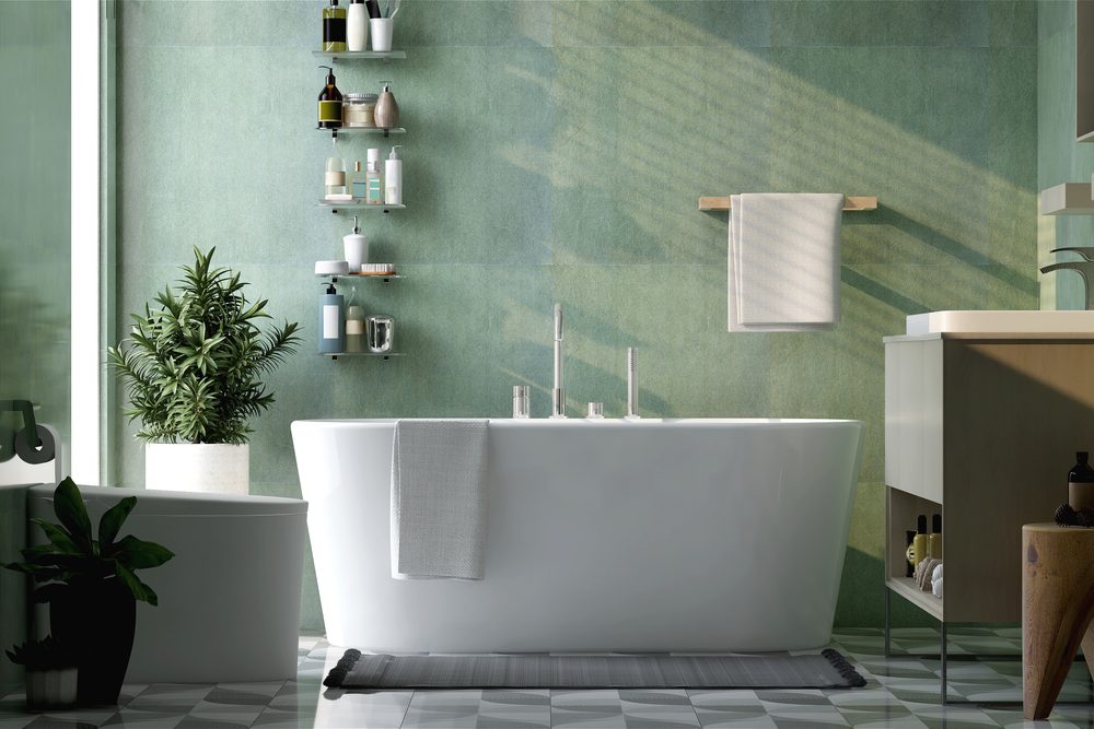 Bathroom shelf with a towel, toothbrush and a few bottles beside a shower curtain
