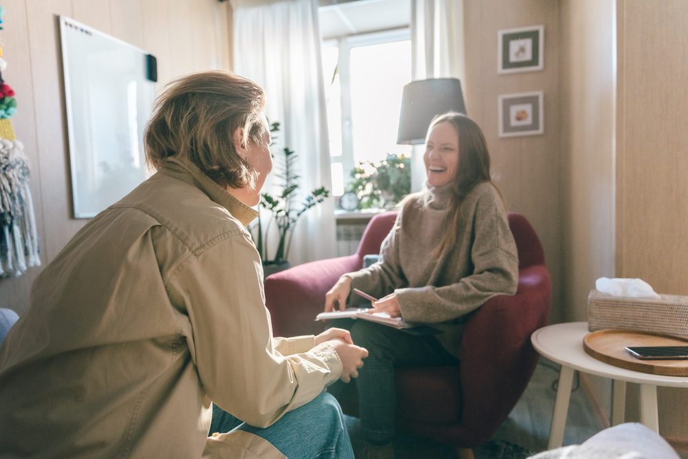 Adult and therapist at a table working through a printed planning worksheet together