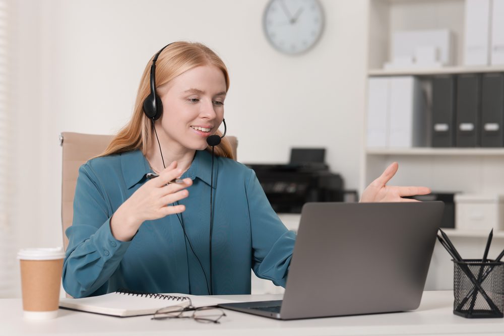 Person typing a prompt into a chat assistant on a laptop beside an open notebook