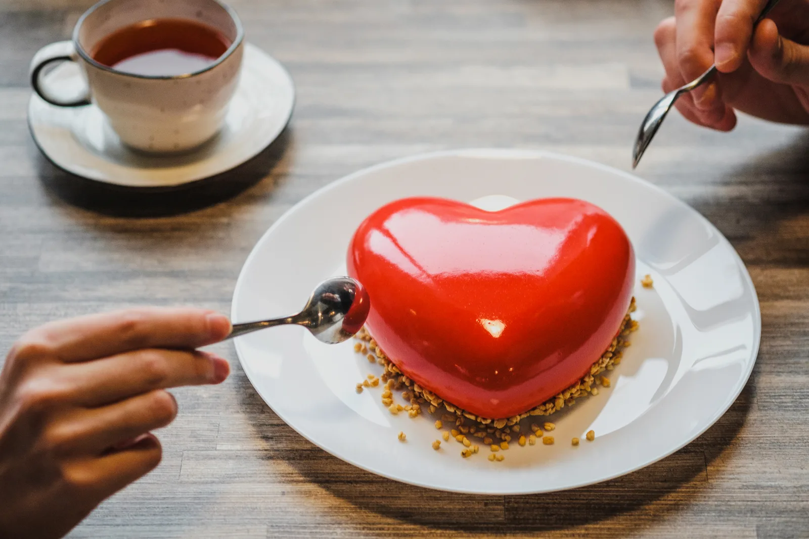 Two adults in a warm, friendly conversation across a cafe table, representing the collaborative relationships at the heart of an ADHD care team.