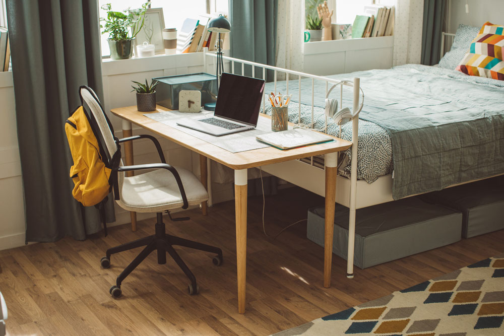 A neatly organized dorm room with a desk, laptop, and study materials, representing how routines and structured environments support students with ADHD in dorm life.