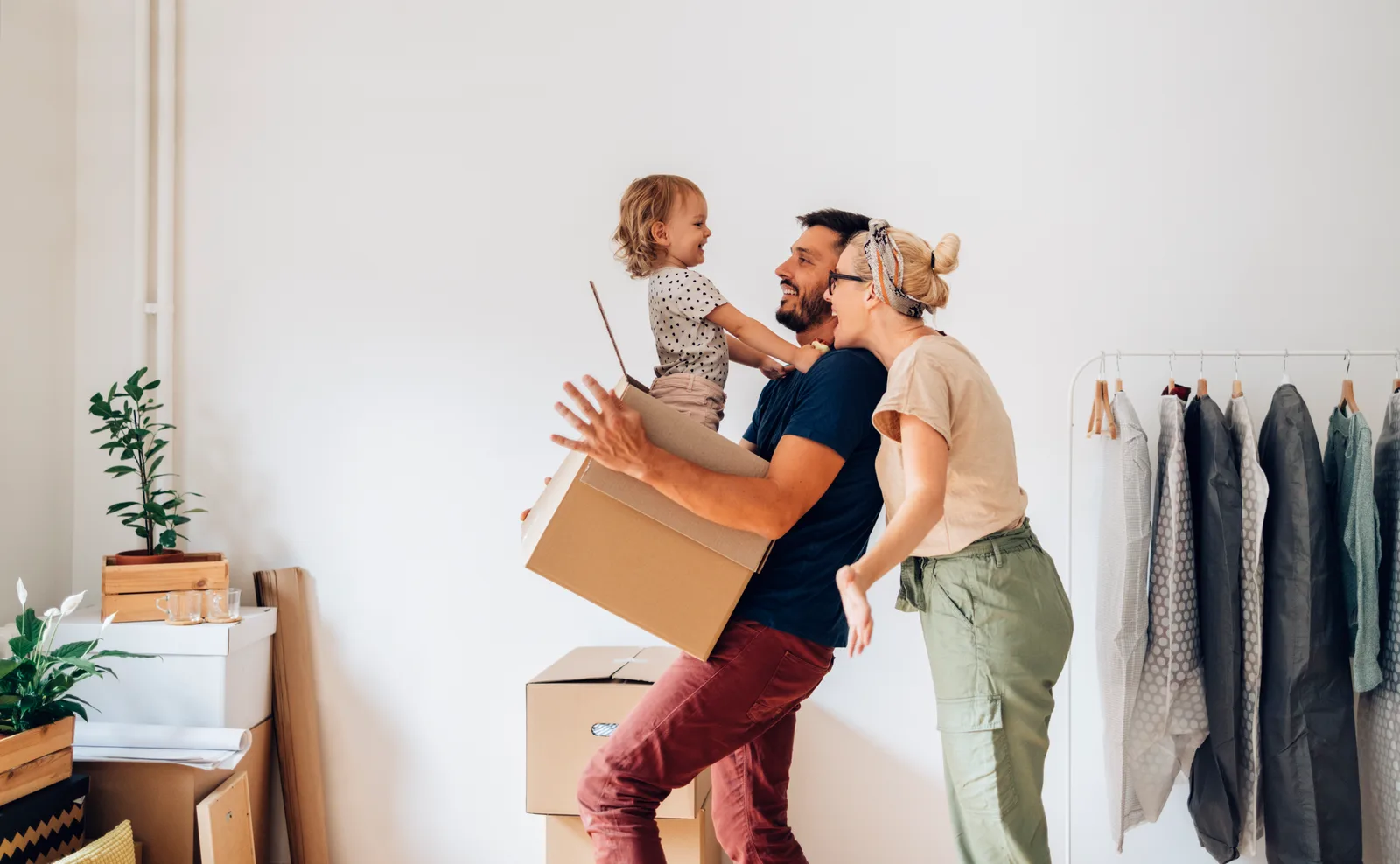 A couple unpacking moving boxes in the living room of their new home, settling into a different Canadian province.