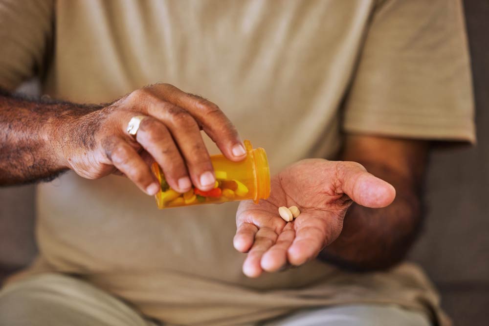 A person pouring prescription medication pills into their hand, representing ADHD medication management and treatment understanding.
