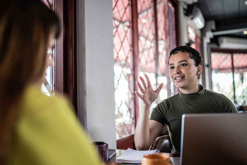 Young professional discussing workplace accommodations with a colleague, representing ADHD advocacy at work.