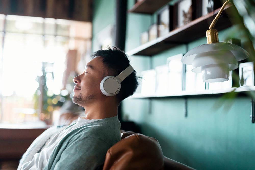 Man relaxing with headphones on, representing strategies for preventing burnout and maintaining mental health with ADHD.