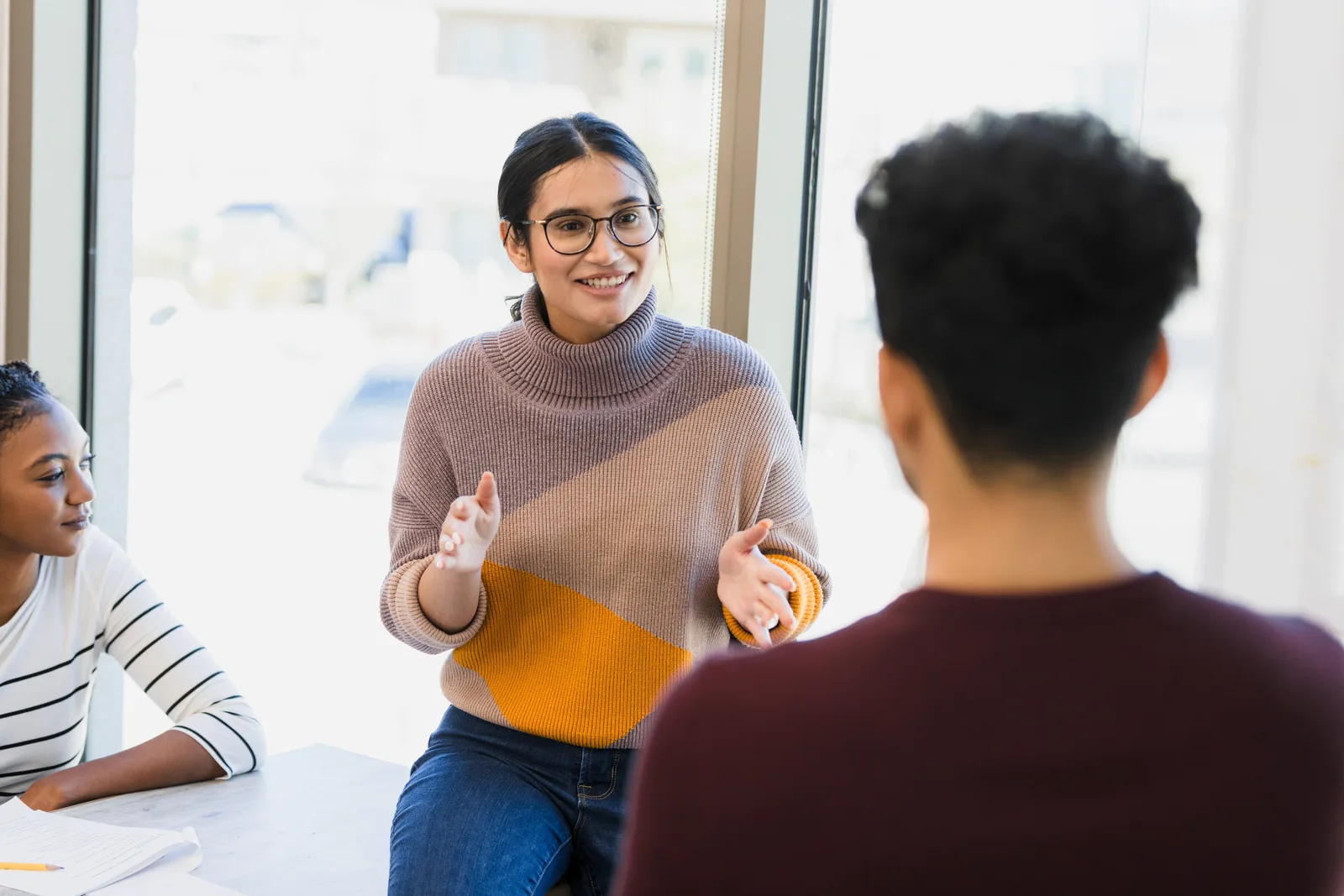 A university student meeting with an accessibility advisor in a bright campus office to register for ADHD accommodations.
