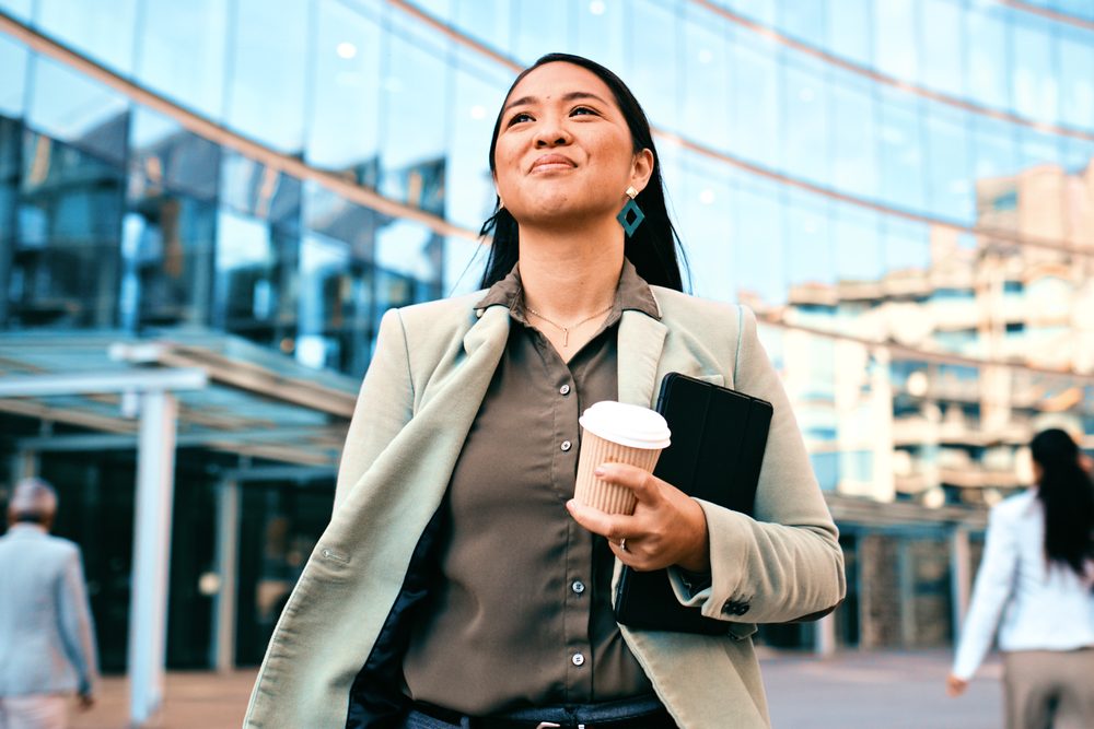 Person walking toward an office building entrance on a quiet morning with a backpack