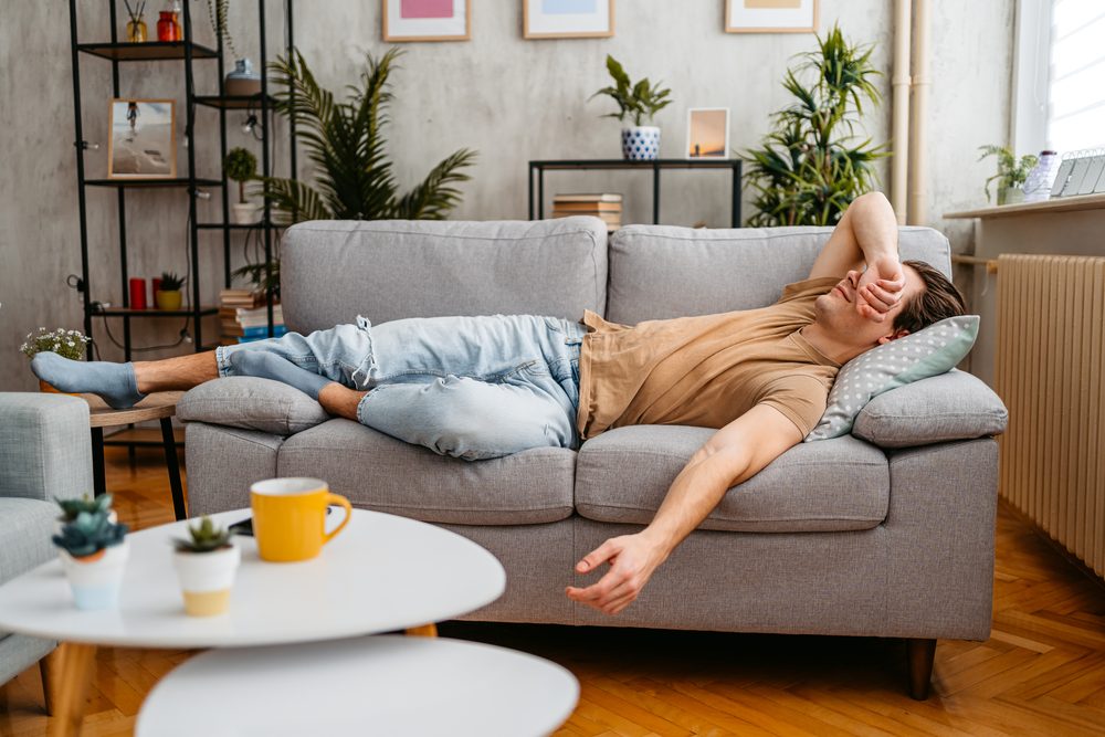 Man asleep in bed wearing a home sleep test nasal cannula and finger sensor