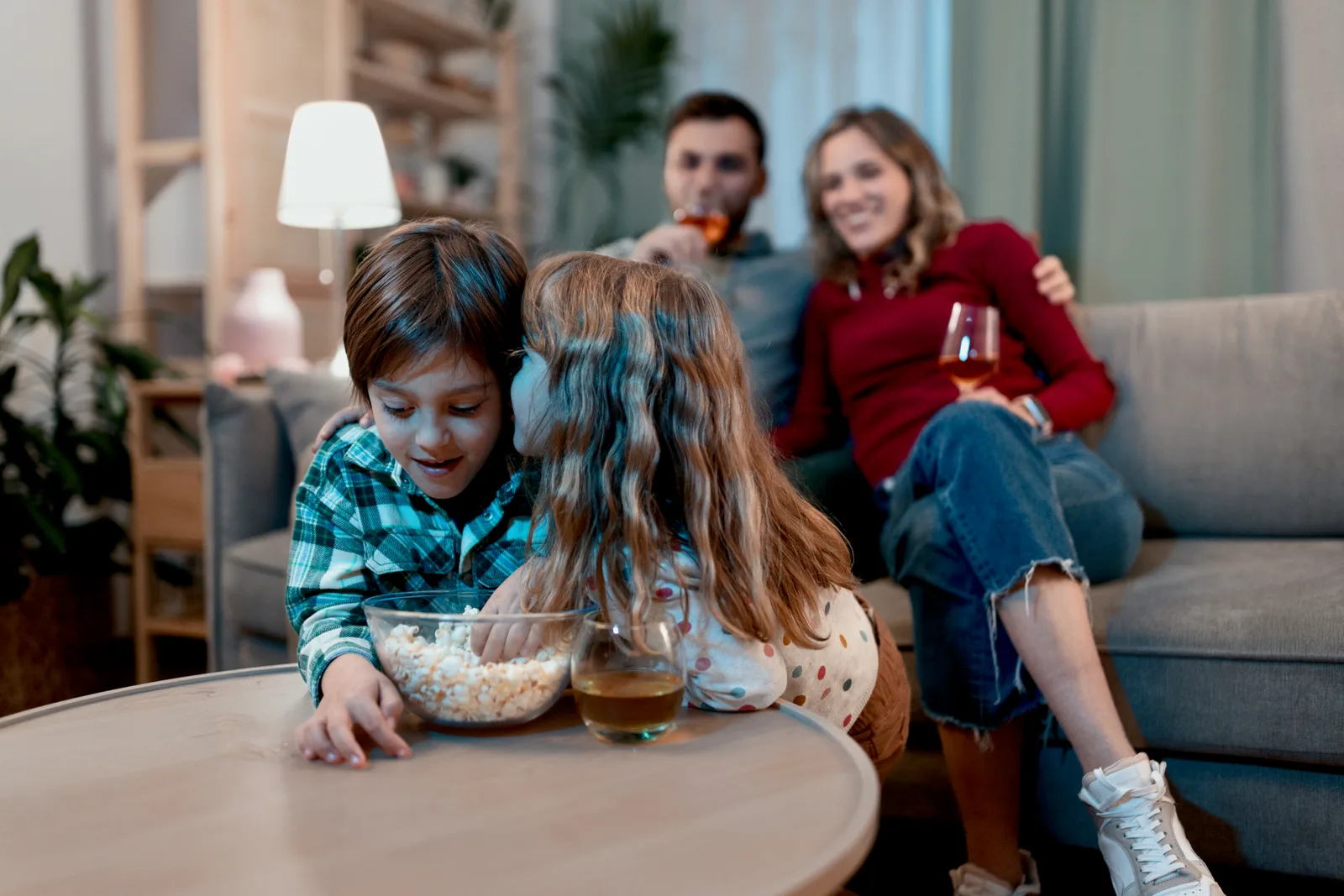 Adult family members talking openly together on a couch in a cozy living room, reflecting the conversation of sharing an ADHD diagnosis with loved ones.