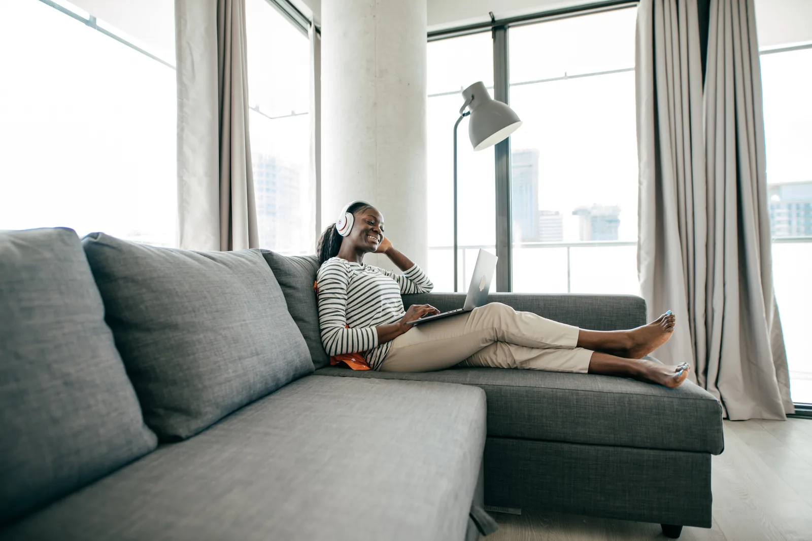 A woman in her Ontario apartment joins an online ADHD assessment from her couch using a laptop